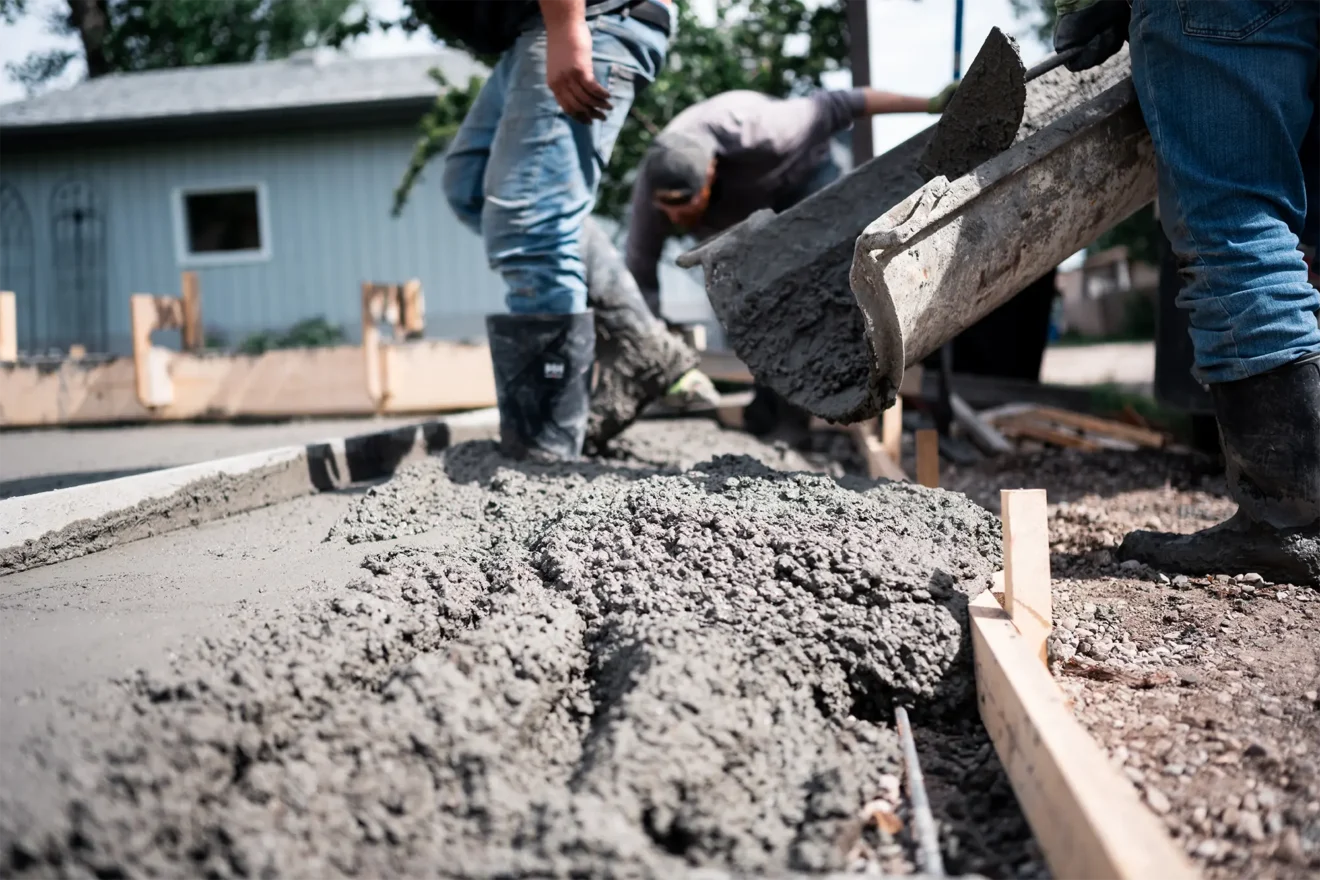 Closeup ground-level view of pouring concrete into forms